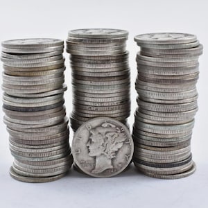 May include: Three stacks of silver coins, each stack is about 100 coins tall. The coins are all silver and have a design on them. The coins in the middle stack are all dated 1943.