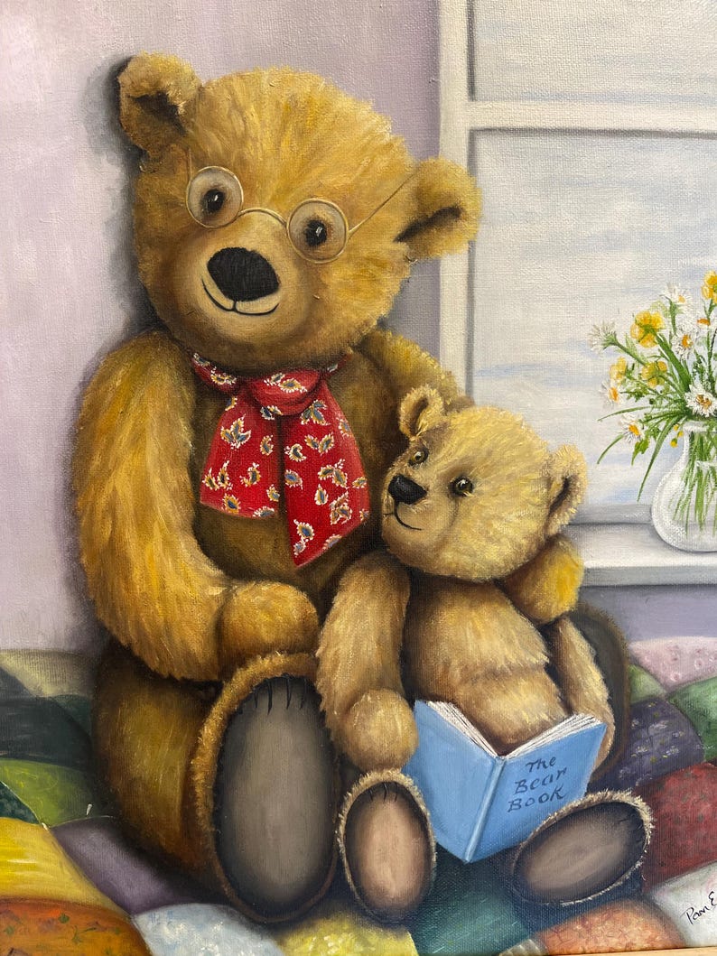 Puede incluir: Dos osos de peluche marrones sentados en una colcha de retazos colorida. El oso m&aacute;s grande lleva gafas y una bufanda roja y blanca. El oso m&aacute;s peque&ntilde;o sostiene un libro azul que dice "The Bear Book".