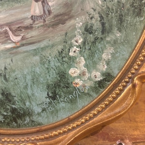May include: A framed painting depicting a woman in a white dress walking with two geese along a path through a green field. The painting is signed "d.t.hanglon" in the bottom right corner.