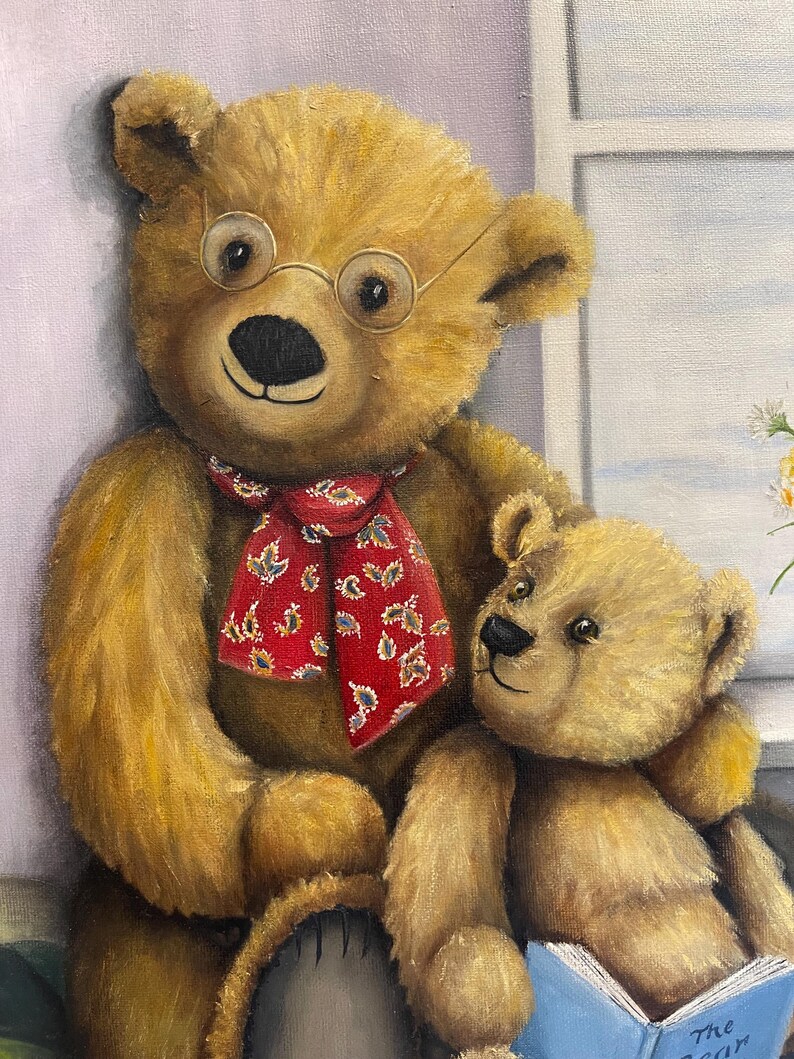 Puede incluir: Dos osos de peluche, uno con gafas y una bufanda roja, est&aacute;n sentados juntos. El oso m&aacute;s grande est&aacute; sosteniendo al m&aacute;s peque&ntilde;o, que est&aacute; leyendo un libro azul con el texto "The Ocean" en la portada.