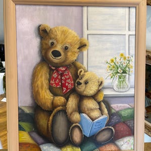 Puede incluir: Una pintura de dos osos de peluche, uno con gafas y una bufanda roja, sentados en una colcha de retazos colorida. El oso m&aacute;s peque&ntilde;o sostiene un libro titulado "The Bear Book".