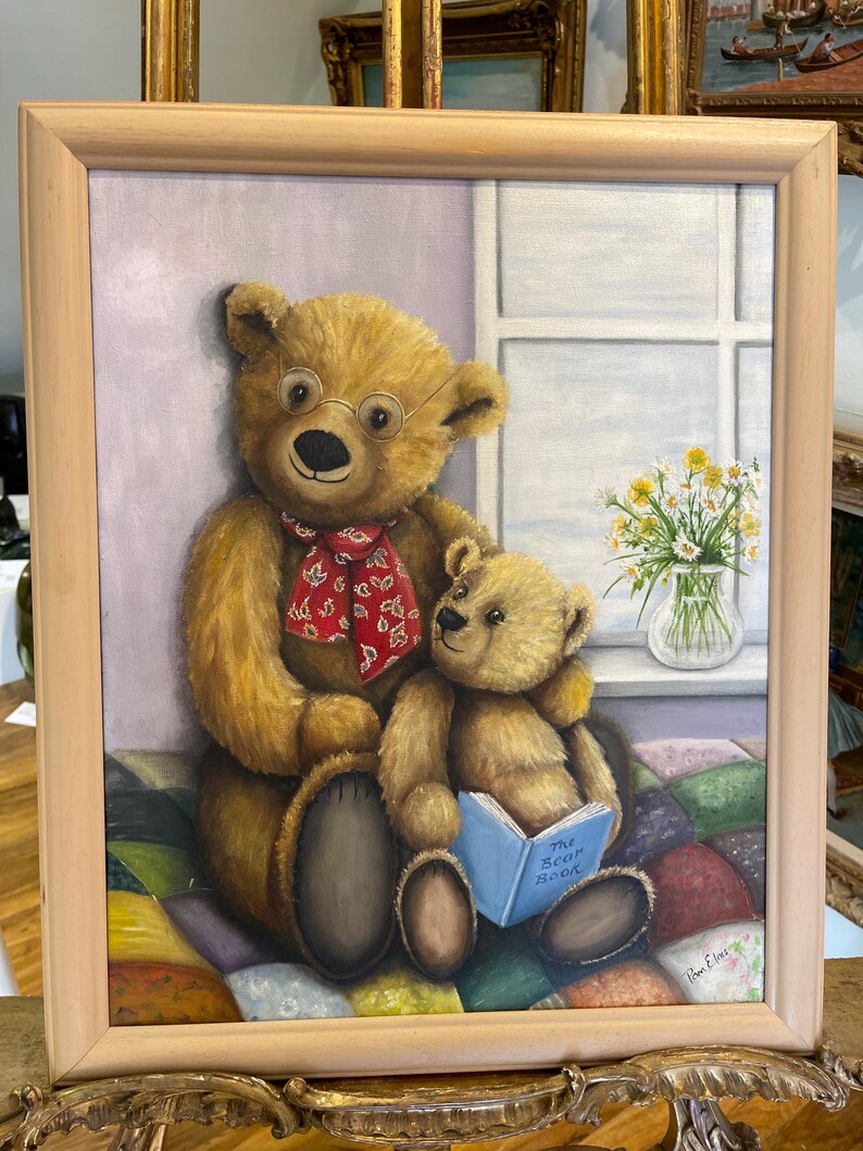 Puede incluir: Una pintura de dos osos de peluche, uno con gafas y una bufanda roja, sentados en una colcha de retazos colorida. El oso m&aacute;s peque&ntilde;o sostiene un libro titulado "The Bear Book".