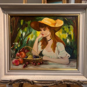 Puede incluir: Una pintura de una mujer con un sombrero de paja amarillo y un vestido blanco, sentada en un jard&iacute;n con una cesta de fruta delante de ella.
