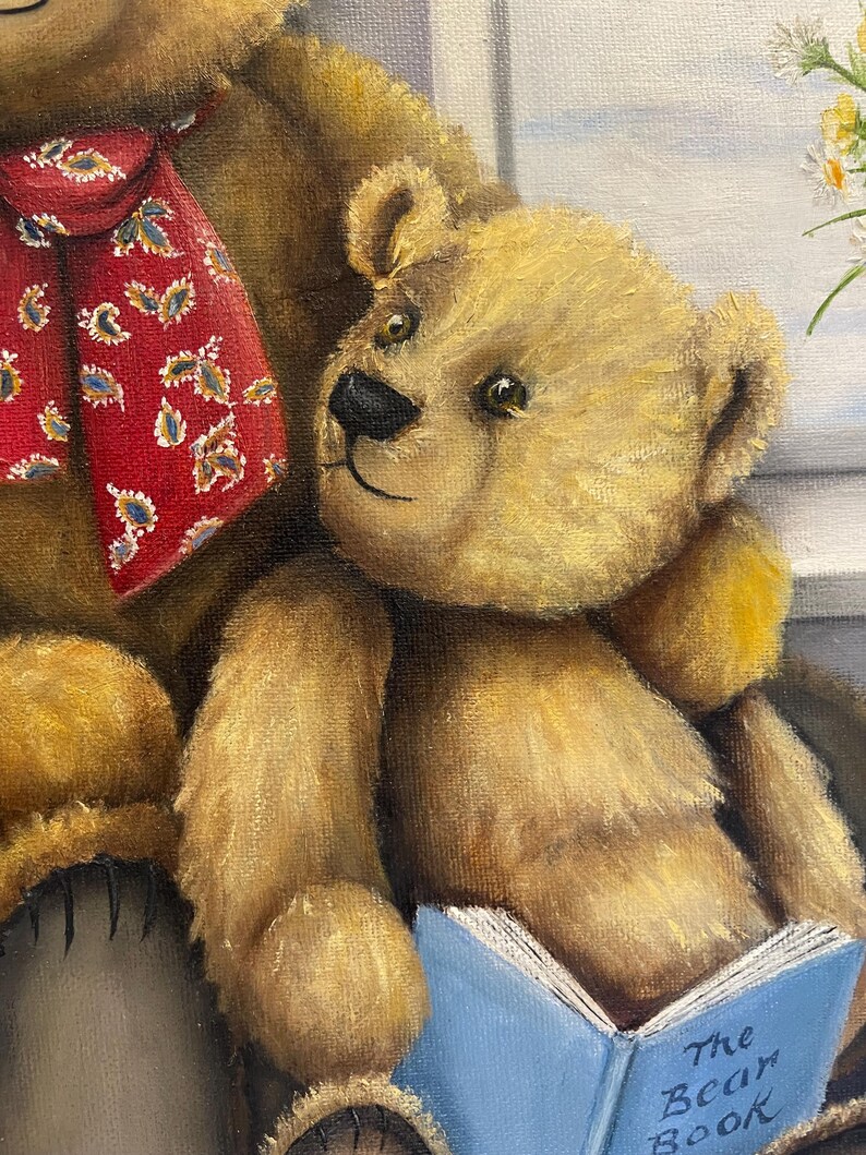 Puede incluir: Dos osos de peluche marrones, uno de ellos con una corbata de estampado paisley rojo y azul, est&aacute;n sentados juntos. El oso m&aacute;s peque&ntilde;o sostiene un libro azul con el t&iacute;tulo "The Bear Book" impreso en la portada.