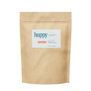 May include: A tan kraft paper pouch containing Huppy strawberry flavored fluoride-free toothpaste tablets. The white label features the brand name Huppy, the text Small changes, big smiles, and indicates a net weight of 2 lb (32 oz).