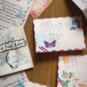 Puede incluir: Una colecci&oacute;n de sobres con varios dise&ntilde;os, incluyendo una mariposa, un ciervo y una fresa. Los sobres est&aacute;n decorados con estrellas, flores y otros detalles caprichosos. El texto en un sobre dice "Save Time".