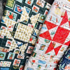 Könnte beinhalten: Zwei Weihnachtsstrümpfe aus Stoff mit Patchwork-Muster. Die Strümpfe sind mit einer Vielzahl von Vintage-Briefmarken verziert, die Weihnachtsmotive wie den Weihnachtsmann, Rentiere und Weihnachtsbäume zeigen. Die Strümpfe sind gesteppt und haben ein rotes und goldenes Sternmuster.