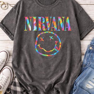 May include: A set of three ceramic mugs with a speckled, matte finish. Each mug features a different color: light blue, cream, and gray. The mugs have a simple, modern design and a comfortable handle.