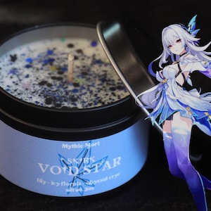 May include: A black metal tin candle with a white wax interior speckled with blue and black glitter. The label reads "Void Star" with "lily-icy florals-abyssal cryo" text. An anime character with white and blue clothing is in the background.