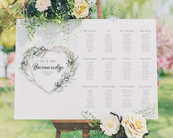 May include: A wedding seating chart with a heart-shaped frame made of olive branches and the text "Mr & Mrs Brownridge" at the top. The chart lists tables with names like "Mt Everest", "K2", "Mt Vesuvius", and "Ben Nevis".