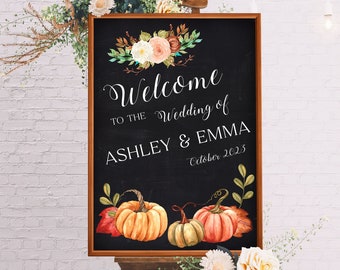 May include: A chalkboard wedding welcome sign with a fall theme. The sign is decorated with a floral wreath, pumpkins, and fall leaves. The text on the sign reads "Welcome to the Wedding of Ashley & Emma October 2023".