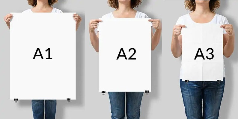 May include: Three people holding up white paper sheets with the letters A1, A2, and A3 printed on them.