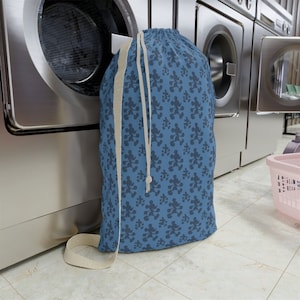 May include: A blue laundry bag with a white drawstring and a repeating pattern of Mickey Mouse silhouettes.