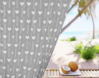 May include: A gray curtain with a white Mickey Mouse pattern hangs open to reveal a beach scene with palm trees and coconuts on a bamboo table.