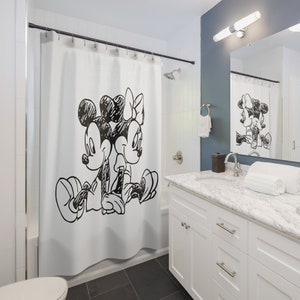 Op de afbeelding: Een douche met een wit douchegordijn waarop een zwart-witte schets van Mickey Mouse en Minnie Mouse te zien is die samen zitten.