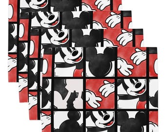 May include: A set of four rectangular placemats featuring a repeating grid pattern of Mickey Mouse. Each square displays either a smiling Mickey Mouse face or a black silhouette of his head against a vibrant red background with white accents.