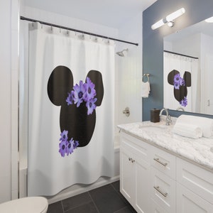 May include: White shower curtain with a black silhouette of Mickey Mouse's head with purple flowers on top.