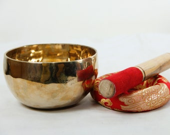 Puede incluir: Un cuenco cantón dorado con un mazo de madera y un cojín rojo con bordados dorados.