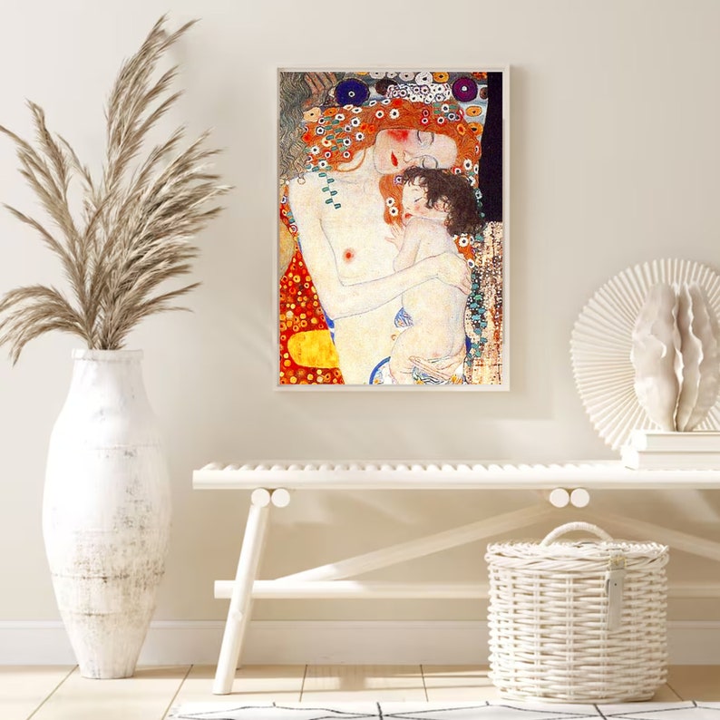 Op de afbeelding: Een schilderij van een moeder en kind die elkaar omhelzen. De moeder heeft lang rood haar en draagt een rode en gele jurk. Het kind draagt een witte jurk. Het schilderij is gemaakt in een stijl die doet denken aan Gustav Klimt.