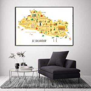 May include: A colorful illustrated map of El Salvador with the names of cities and towns labeled. The map is framed in a black frame and is hanging on a white wall.
