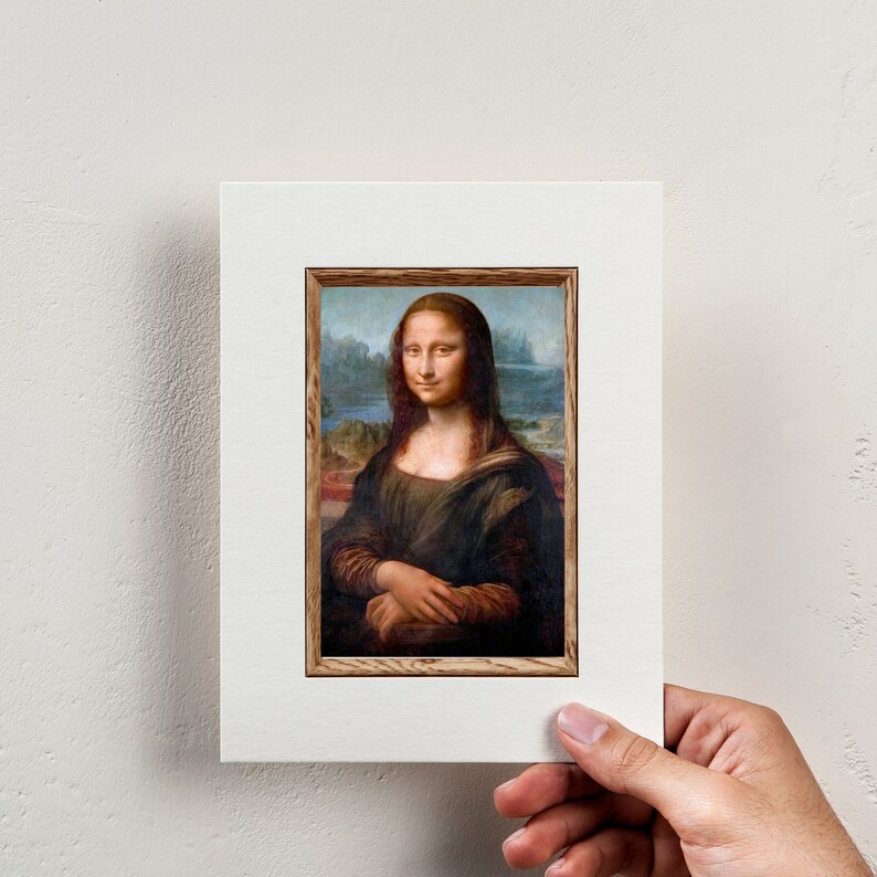 May include: A framed print of the Mona Lisa painting. The painting features a woman with a soft smile, wearing a dark dress and a light background.
