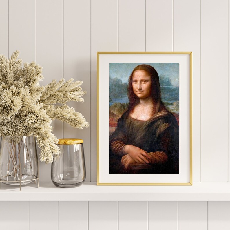 May include: A framed print of the Mona Lisa painting. The painting features a woman with a soft smile, wearing a dark dress and a light background.