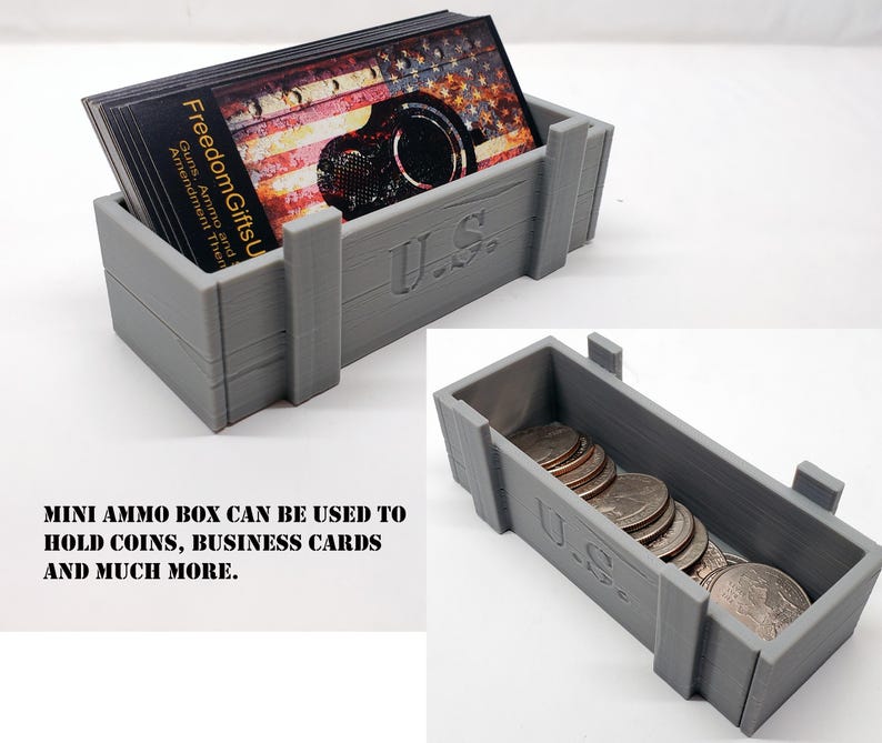 May include: A gray, rectangular mini ammo box with the text "U.S." on the front. The box is filled with business cards and coins. The business cards have an American flag design and the text "Freedom Gifts U".