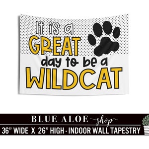 May include: White tapestry with black polka dots and a black paw print. The text "It is a GREAT day to be a WILDCAT" is in yellow letters. The tapestry is 36 inches wide and 26 inches high.