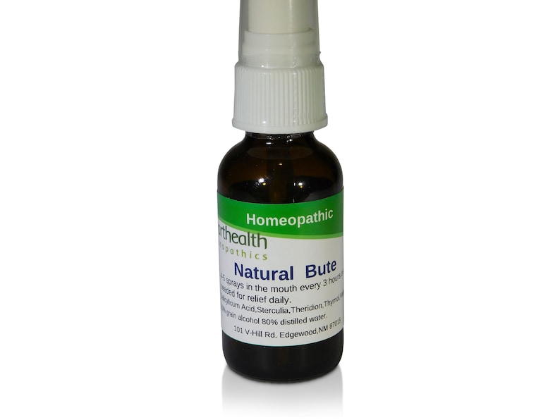 May include: A brown glass bottle with a white spray nozzle. The bottle is labeled "Natural Bute Homeopathic" and contains a liquid. The label also includes the text "101 V-Hill Rd. Edgewood, NM 87015".