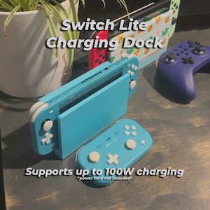 May include: A teal Switch Lite charging dock with a matching controller. The dock supports up to 100W charging. The image also shows a purple controller and a decorative Switch Lite case.
