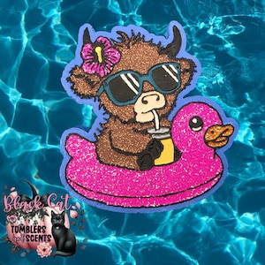 May include: A brown glittery cow wearing sunglasses and a flower, floating on a pink glittery duck-shaped pool float. The cow is holding a drink with a straw. The image is set against a blue water background.