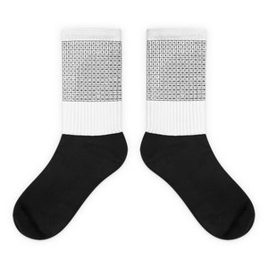 May include: A pair of black and white socks. The top of each sock features a multiplication table in a grid format. The socks have a white upper section and a black foot section. The multiplication table is printed in black.