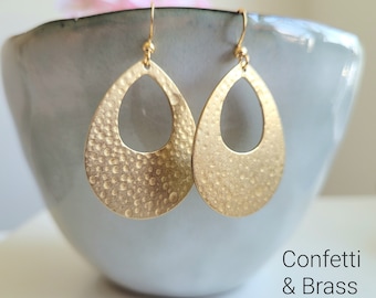 Golden earrings with brass pendants hammered in a teardrop shape and stainless steel ear hooks