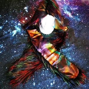 May include: A colorful faux fur hooded scarf with a galaxy print satin lining. The scarf is displayed on a black background with a galaxy print.