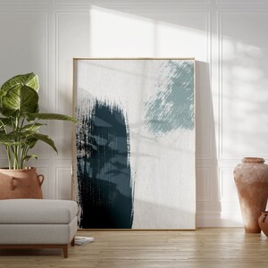 May include: Abstract art print with blue and white brushstrokes in a gold frame hanging on a white wall with a potted plant and two terracotta vases on the floor.