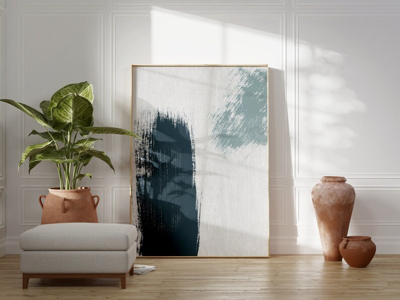 May include: Abstract art print with blue and white brushstrokes in a gold frame hanging on a white wall with a potted plant and two terracotta vases on the floor.