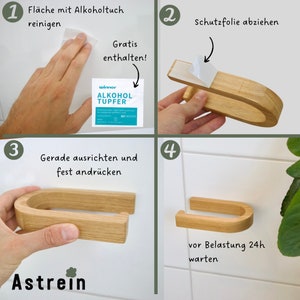 May include: Four steps for installing a wooden toilet paper holder with adhesive backing. The steps are: 1. Clean the surface with an alcohol wipe. 2. Remove the protective film. 3. Align the holder and press firmly. 4. Wait 24 hours before using.
