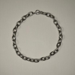 Könnte beinhalten: Eine silberne Kettenkette mit einem einfachen, ovalen Gliederdesign.