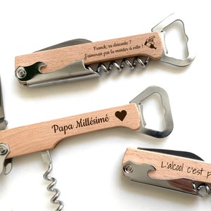 May include: Three wooden handled multi-tools with engraved text. The top tool has the text "Franck, sa descente? J'aimerais pas la monter &agrave; v&eacute;lo!" The middle tool has the text "Papa Mill&eacute;sim&eacute;" and a heart. The bottom tool has the text "L'alcool c'est pas cool?!"