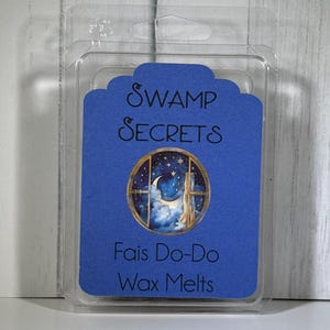 May include: A clear plastic clamshell package containing wax melts. The blue label reads "Swamp Secrets" and "Fais Do-Do Wax Melts." The label features a circular image of a night sky scene with a crescent moon and stars.