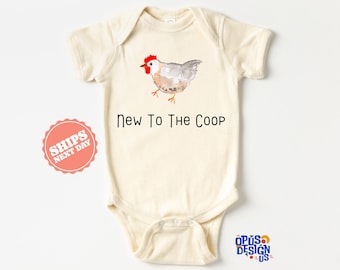 May include: A cream-colored baby onesie with a watercolor illustration of a chicken and the text "New To The Coop".