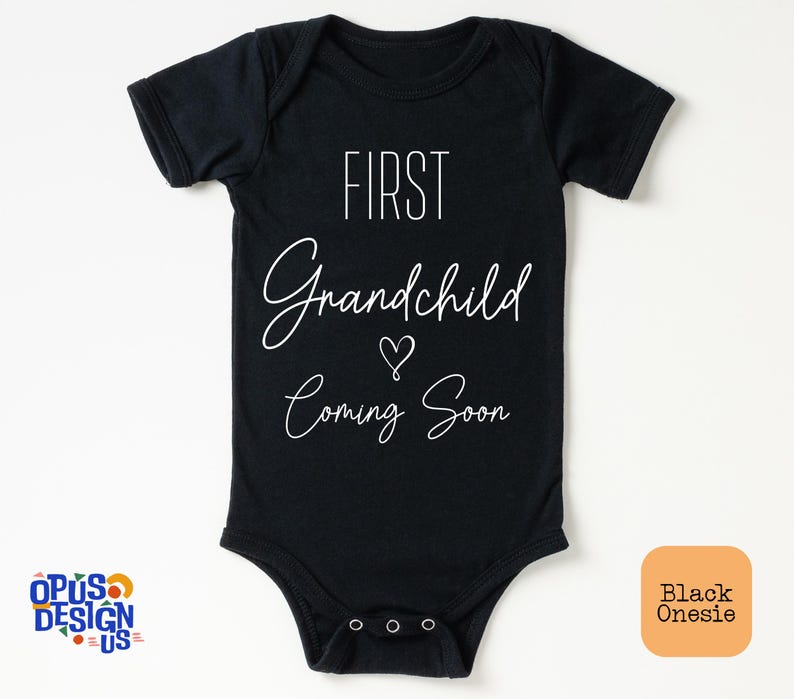 May include: Black onesie with white text that reads "First Grandchild Coming Soon" with a heart symbol.