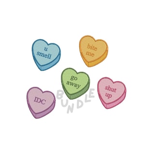 May include: Five colourful heart-shaped candy conversation hearts with different messages: "u smell", "bite me", "go away", "idc", and "shut up".