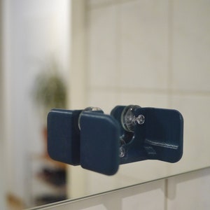 May include: A dark blue plastic shower caddy with two suction cups. The caddy is designed to hold small items like shampoo bottles or razors.