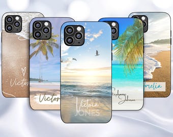 May include: Five different phone cases with beach scenes. The cases are all black and have a clear plastic back. The scenes include a beach with palm trees, a beach with a sunset, a beach with waves crashing on the shore, and a beach with a palm tree and a swing. The cases all have names printed on them, including "Victoria Jones", "Stephanie Johnson", "Amelia", and "Victor".