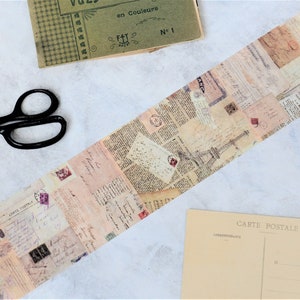 May include: A roll of decorative washi tape with a vintage Parisian theme. The tape features a collage of old letters, stamps, and newspaper clippings with a faded, antique look. The Eiffel Tower is prominently displayed in the center of the tape.