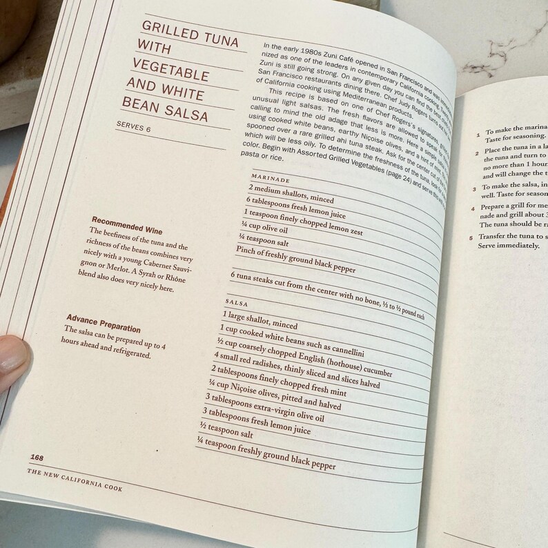 May include: Open cookbook page with a recipe for Grilled Tuna with Vegetable and White Bean Salsa. The recipe includes ingredients for marinade and salsa, with a wine recommendation. The page is from "The New California Cook."