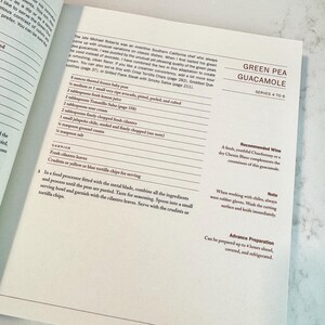 May include: Open cookbook page with a recipe for Green Pea Guacamole. The recipe includes ingredients like peas, avocado, lemon juice, and cilantro. The text also suggests serving with tortilla chips.