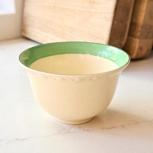 May include: A set of three ceramic mugs with a speckled, matte finish. The mugs are in shades of cream, light gray, and dark gray. Each mug has a simple, minimalist design and a rounded handle.