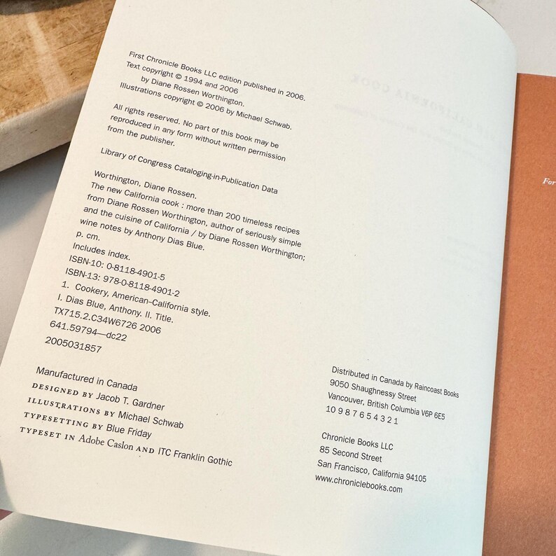 May include: Open book pages with text, including copyright information, Library of Congress data, and ISBN numbers. The book is titled "The new California cook" by Diane Rossen Worthington. The book was manufactured in Canada.
